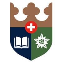 A shield with a book, flower, and plus sign representing global school excellence and education standards.