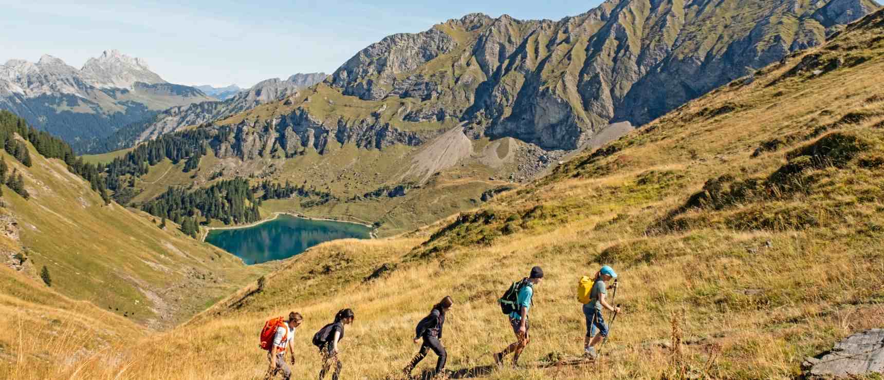 Scenic mountain hiking with students exploring nature in a lush alpine landscape.