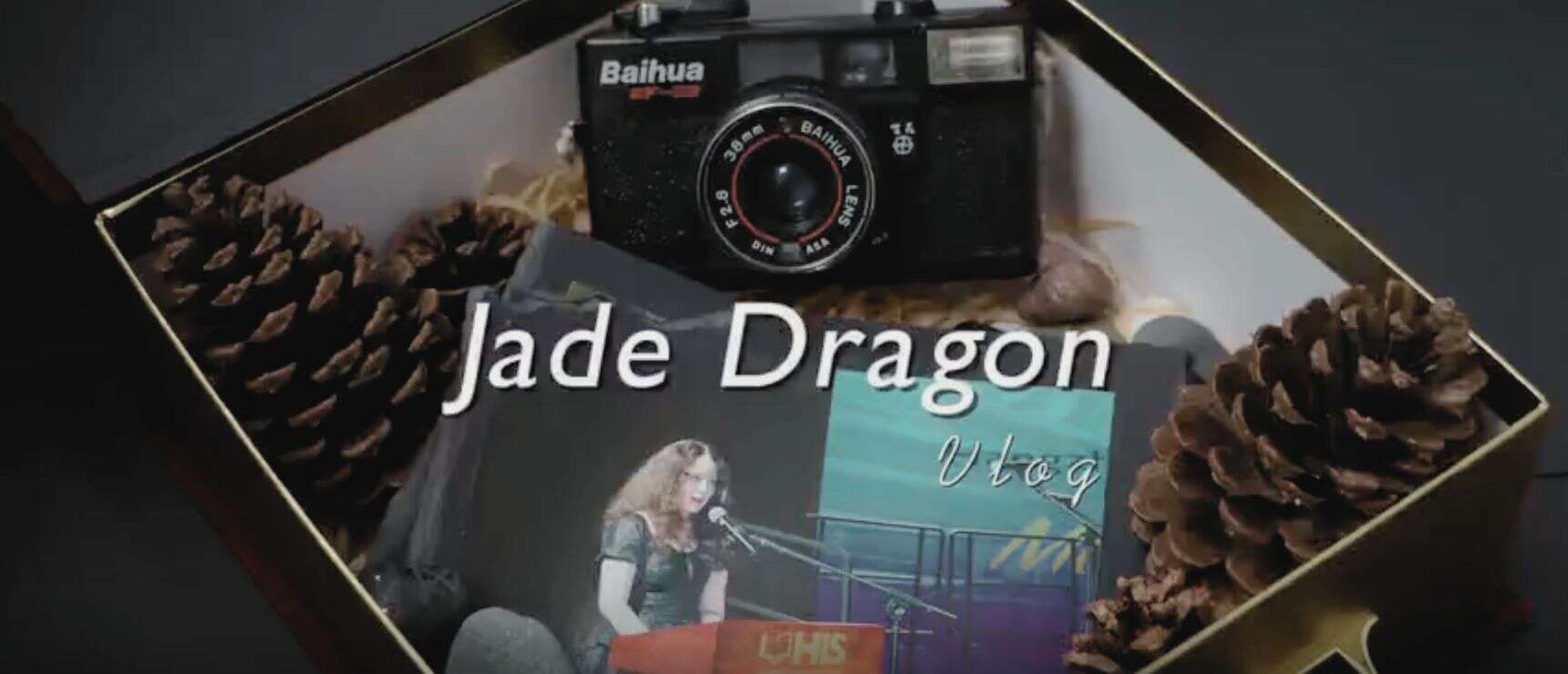 Vintage camera and pinecones in gift box for school vlog thumbnail.