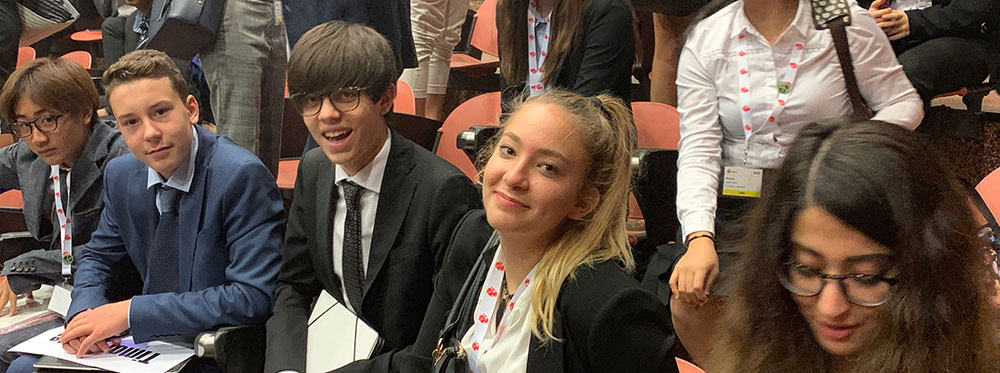 Diverse students at a formal academic conference, emphasizing the importance of global education and international school networks.