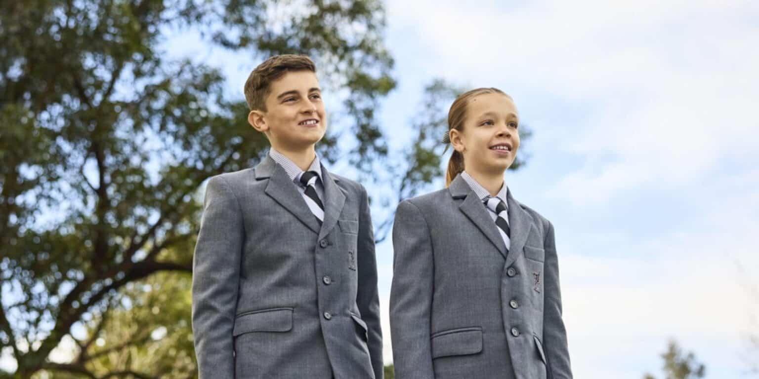 Okul üniformalı çocuklar, Dünya Okullarında en iyi uluslararası eğitimi temsil eden ağaçlarla birlikte açık havada duruyorlar.