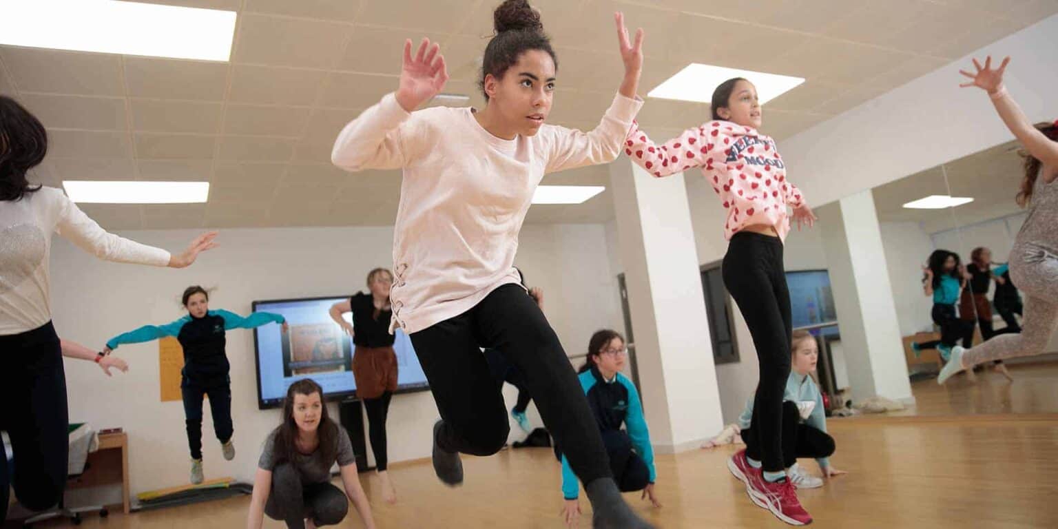 Vibrant students engaging in indoor dance or exercise class at a World Schools educational environment.