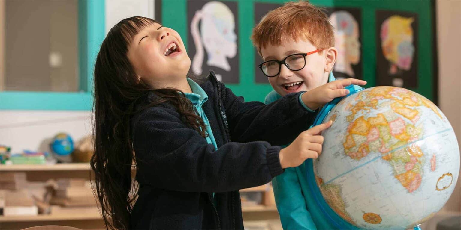Students exploring a world globe in a classroom environment.