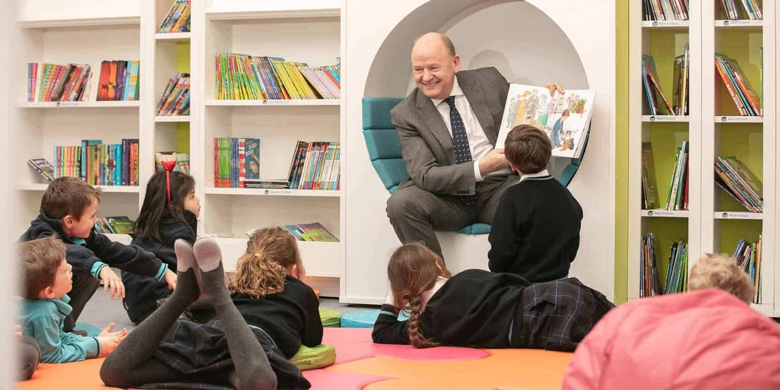 Emotive storytelling in schools, young students enjoying interactive reading with teacher.