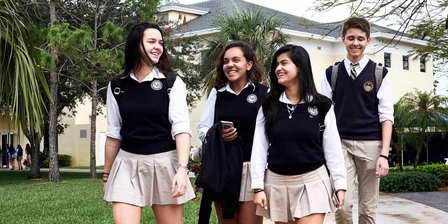 Diverse students walking and smiling outside a modern school building, showcasing international education at top World Schools.