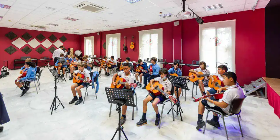 Students playing guitars in a music classroom at World Schools; fostering creativity and musical skills.