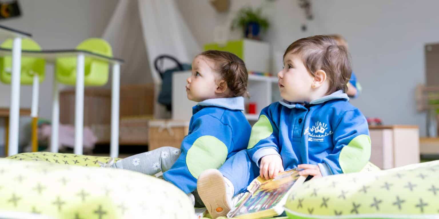 Bright preschool children sitting on a soft mat in a colorful classroom, engaging in early childhood education at an international school.