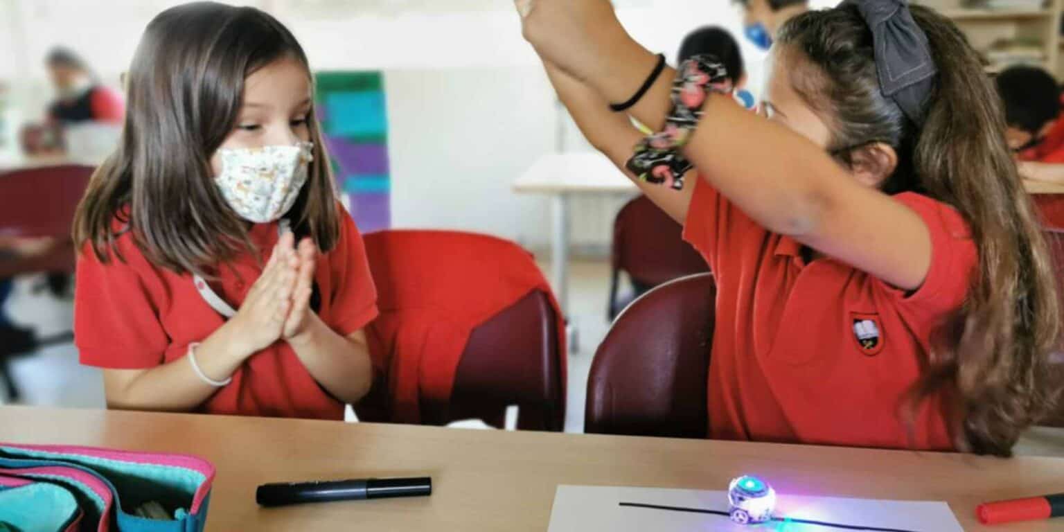 Dünya Okulları ortamındaki fütüristik bir sınıfta eğitim faaliyetlerine katılan çocuklar.