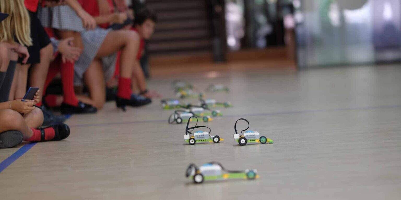 Bir okul robotik etkinliği sırasında spor salonunun zeminindeki küçük eğitim robotları.