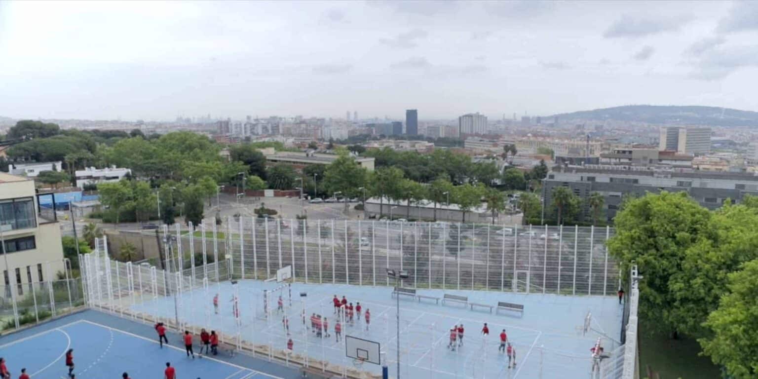 Kentsel bir ortamda yer alan bir dünya okulunda öğrencilerin aktif olarak oynadığı modern bir açık hava basketbol sahası.