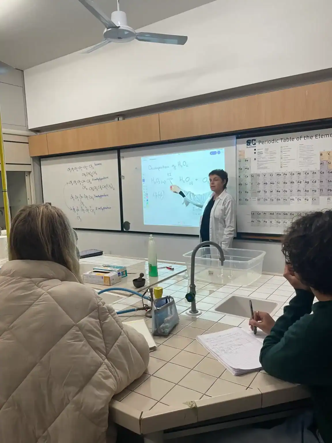Interactive science class at a world school with students learning chemistry concepts.