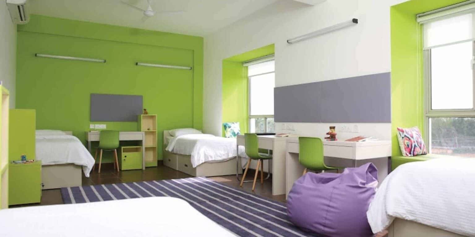 Bright green and white student dormitory rooms with multiple beds and study areas, designed for comfort and learning.