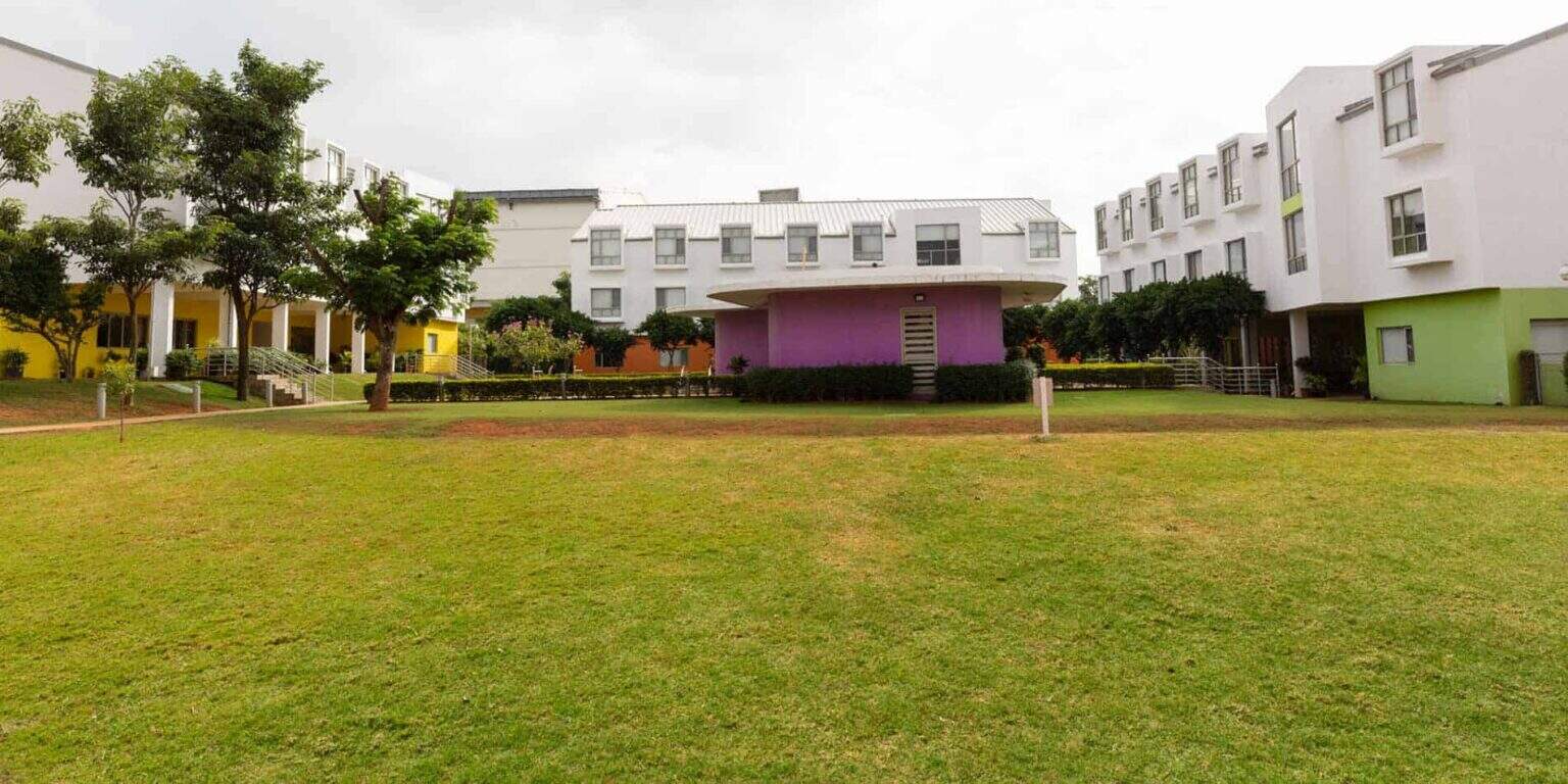 Colorful modern school buildings with well-maintained green lawn, ideal for international students, from World Schools.