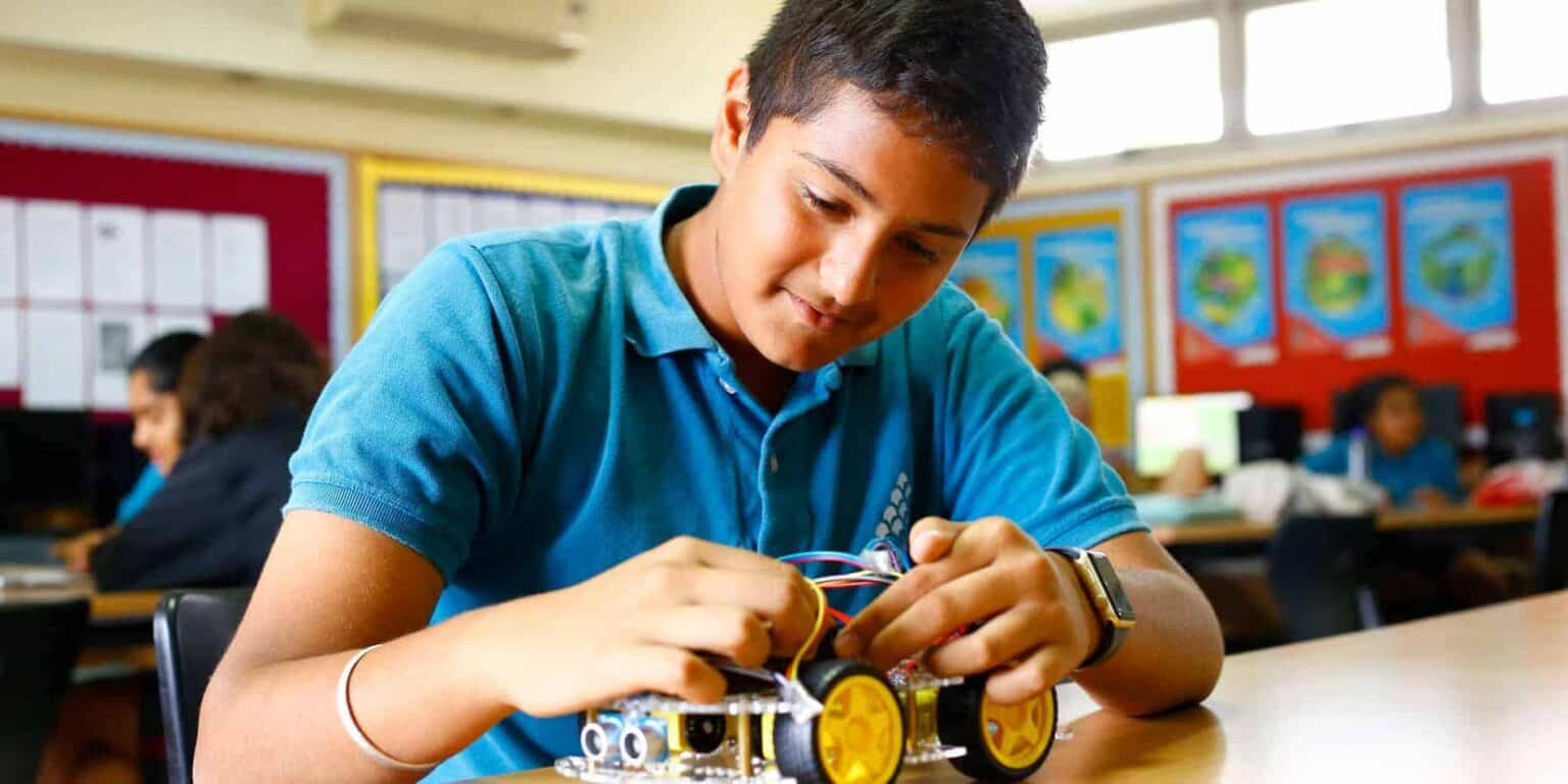 Boy working on robotics project in classroom, engaging in STEM education at World Schools.