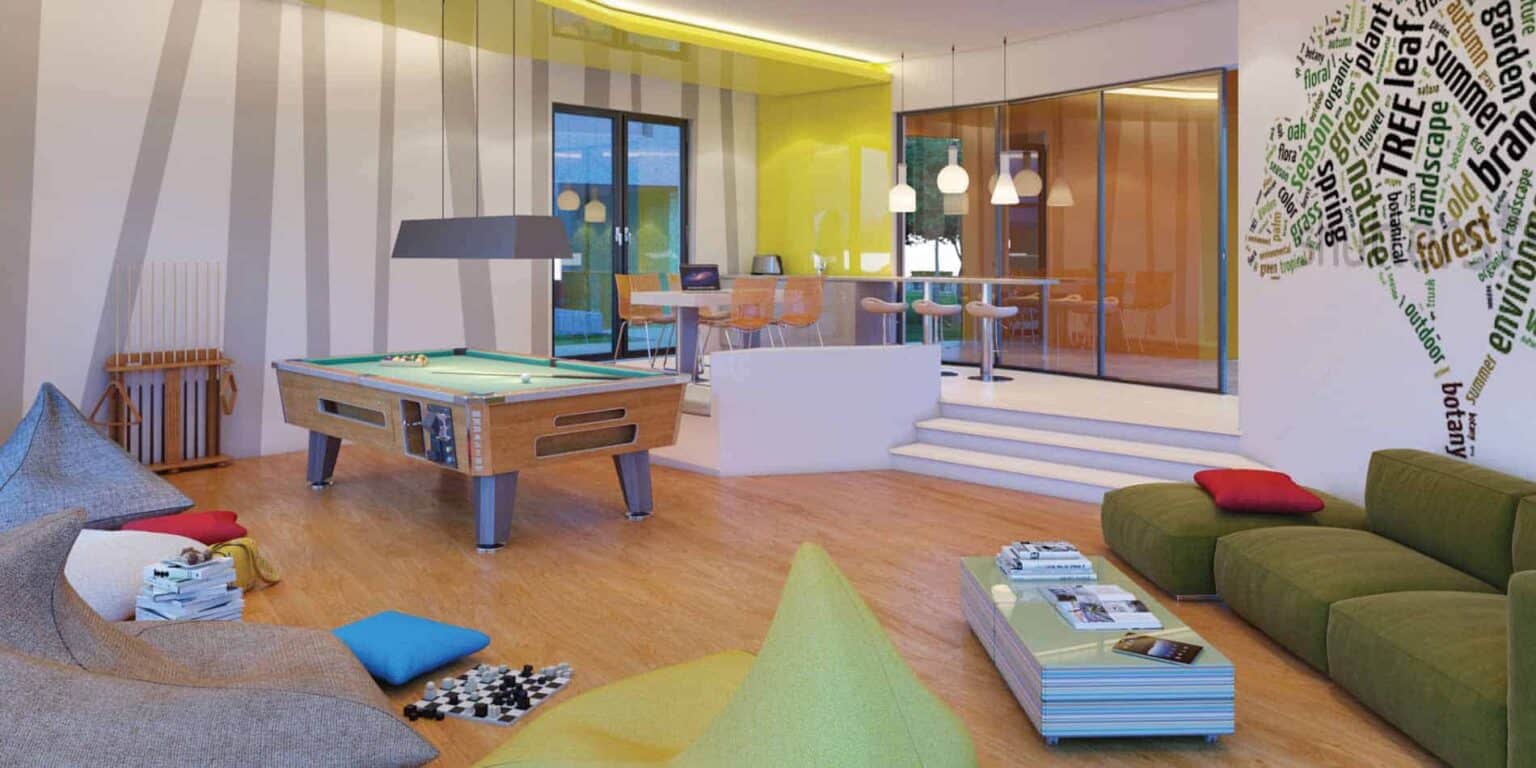 Bright modern student lounge with gaming table, colorful seating, and motivational words wall art.