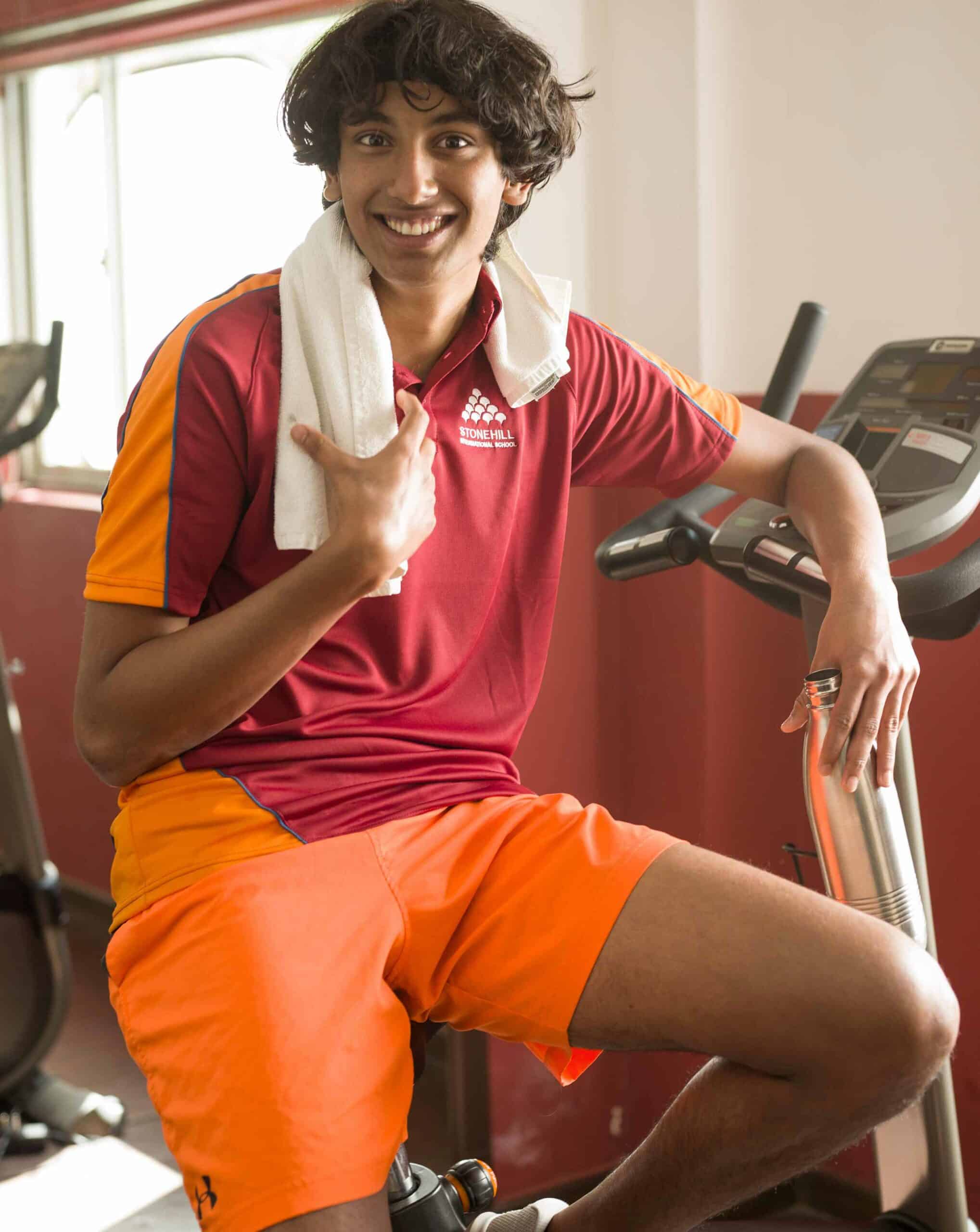1. Smiling student with towel on shoulder at gym at World Schools.