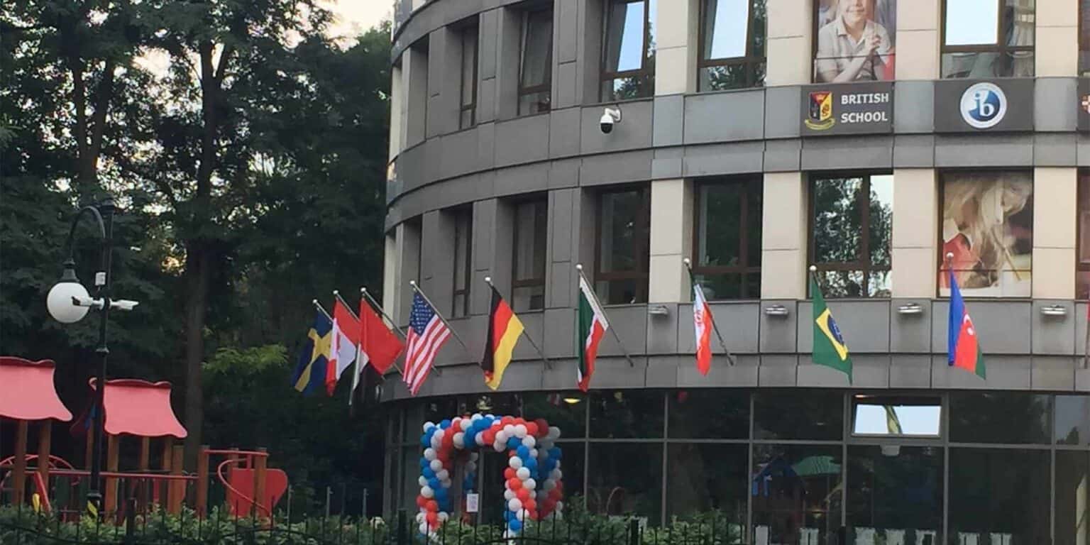 Bright international school with flags, balloons, and modern architecture for global student community.