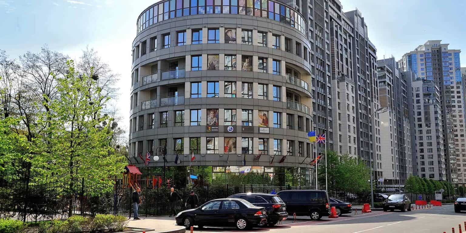 Modern high-rise building housing international schools and educational institutions in an urban setting.