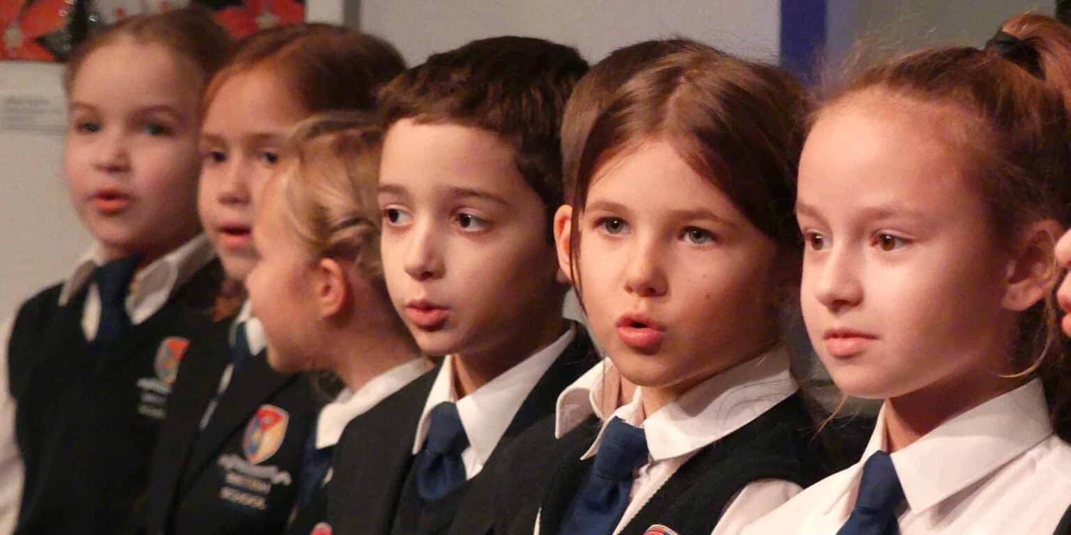 Children in school uniforms attending a world school event, demonstrating global education and diverse student community.