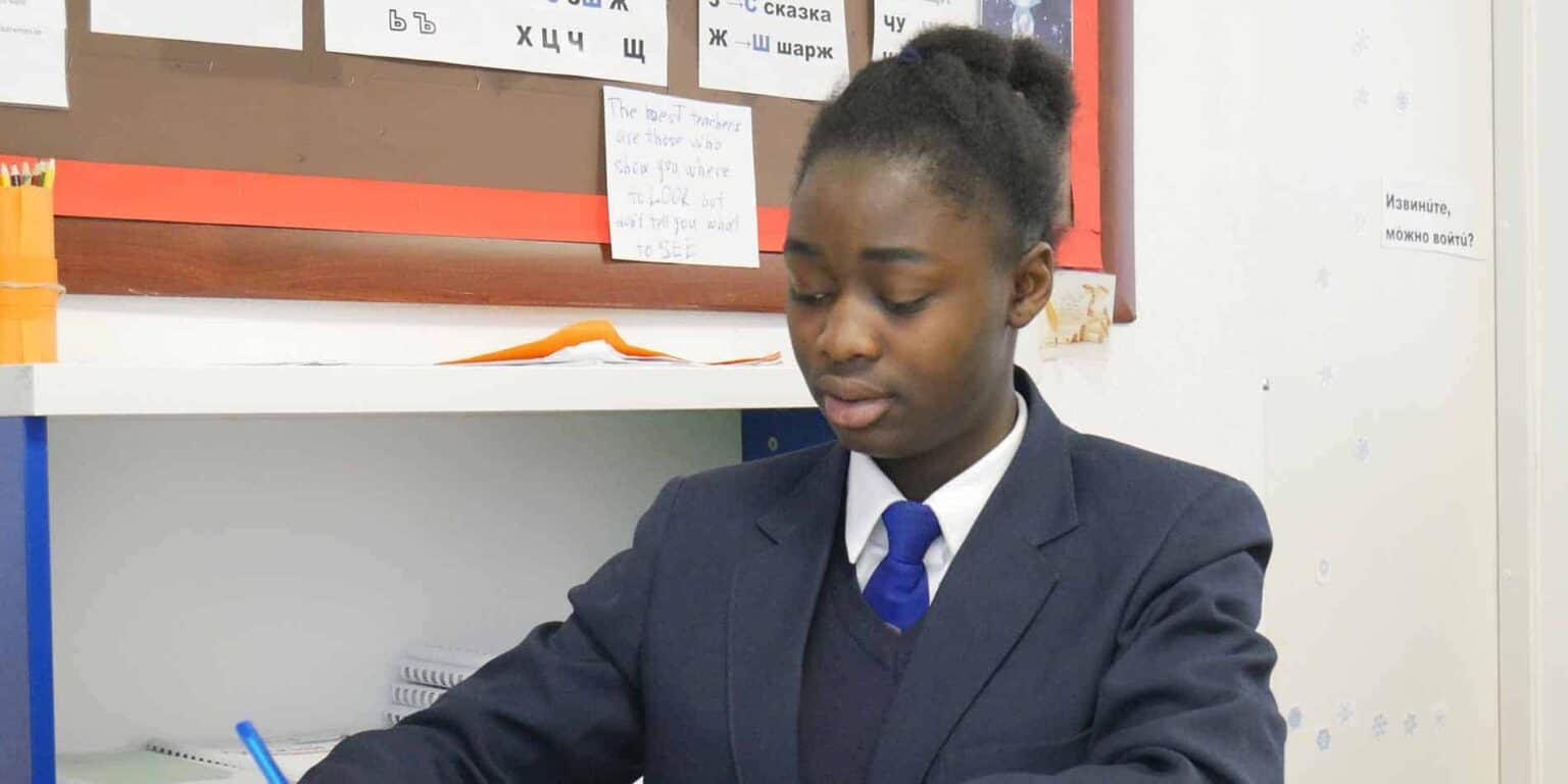 Young student studying in a classroom at an international school, focusing on learning and academic excellence.
