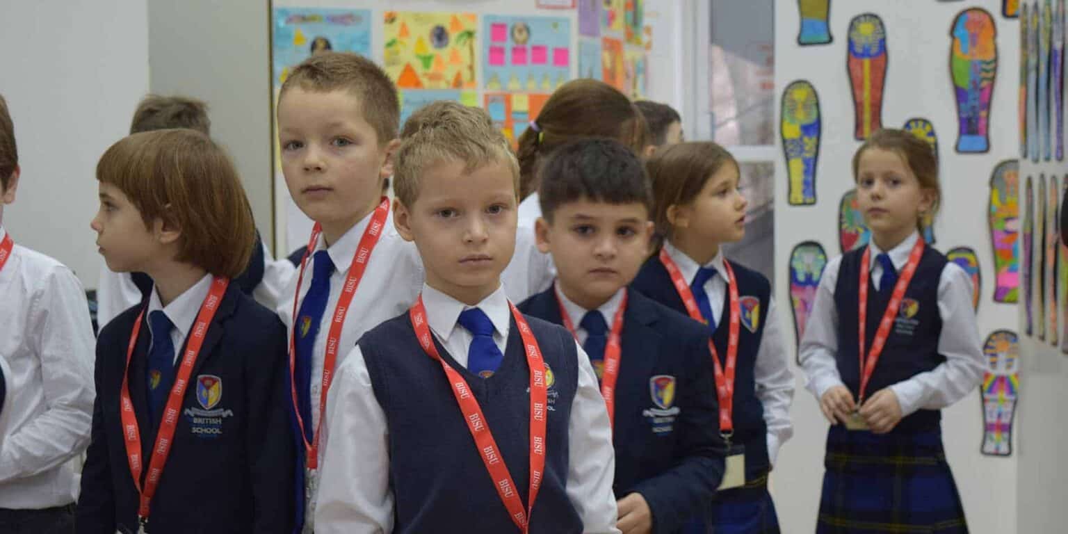 Young students in uniform during a school event at a British curriculum school in the UK.