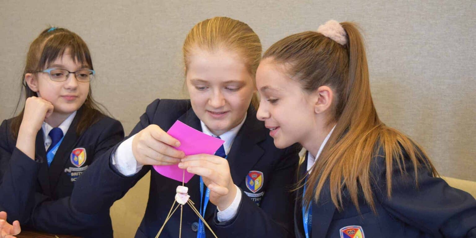 Students in school uniforms engaging in a collaborative project at World Schools.