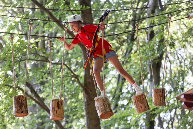 This Month at TASIS: June 2024 9 Child climbing adventure course in a forest outdoor activity.