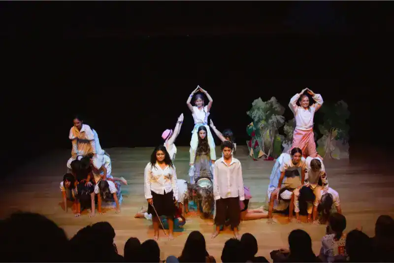 This Month at TASIS: June 2024 42 Children performing a cultural dance on stage at a world schools event.