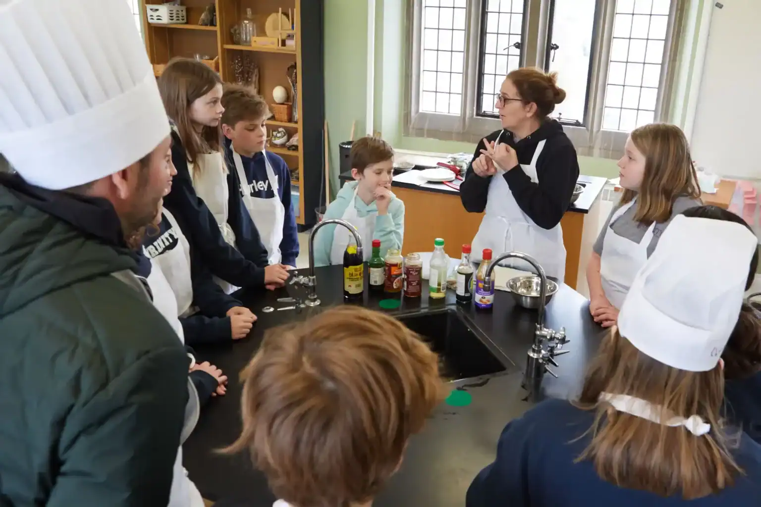 Cooking class with children and a teacher at a world school, focusing on culinary skills and international education.