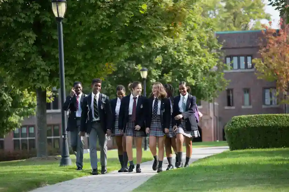 Brightly dressed students walking outdoors at a prestigious international school campus.