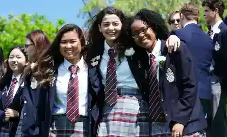 Diverse students celebrating outdoors at a world school campus, fostering global education and cultural diversity.
