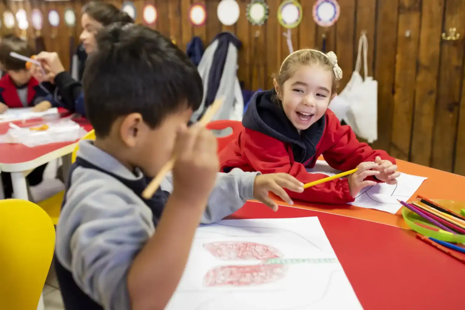 ワールド・スクールで創造的なアート活動に取り組む子どもたちの笑顔が印象的なカラフルな教室の様子。.