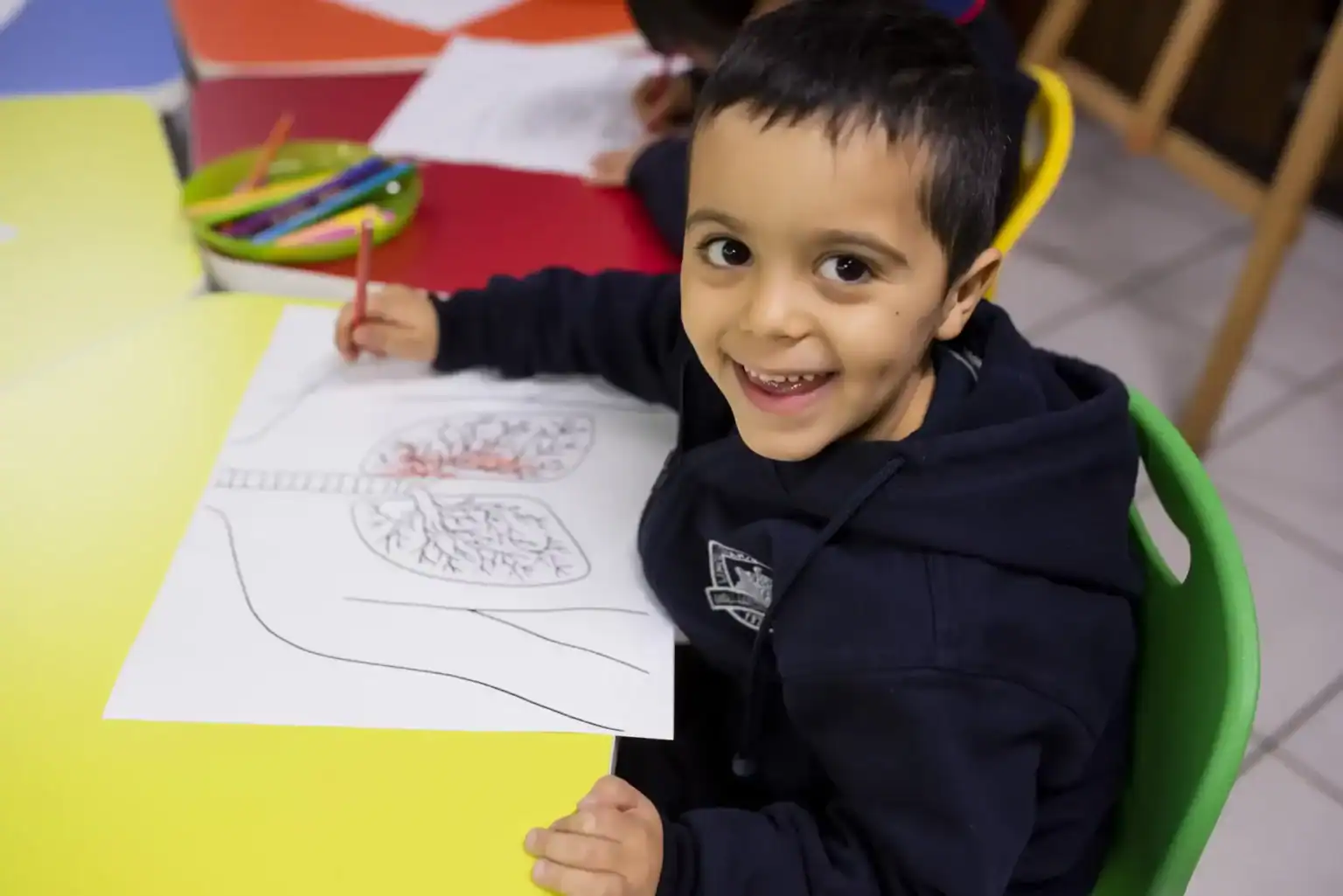 学校で塗り絵をする明るい少年、学習活動に取り組む陽気な子供。.