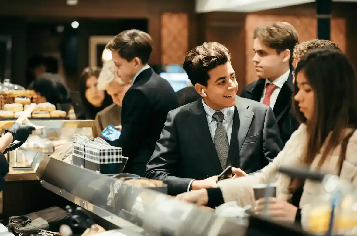 Elegant students engaging at a school cafeteria, showcasing social skills and diversity in an international education environment.