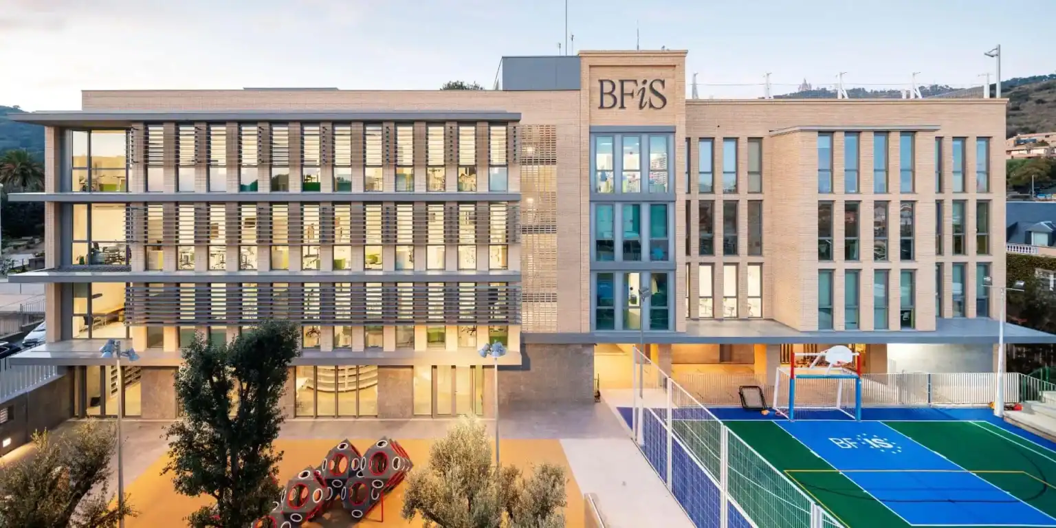 Modern school building with sports courts and outdoor play areas, showcasing a conducive environment for learning and recreation.