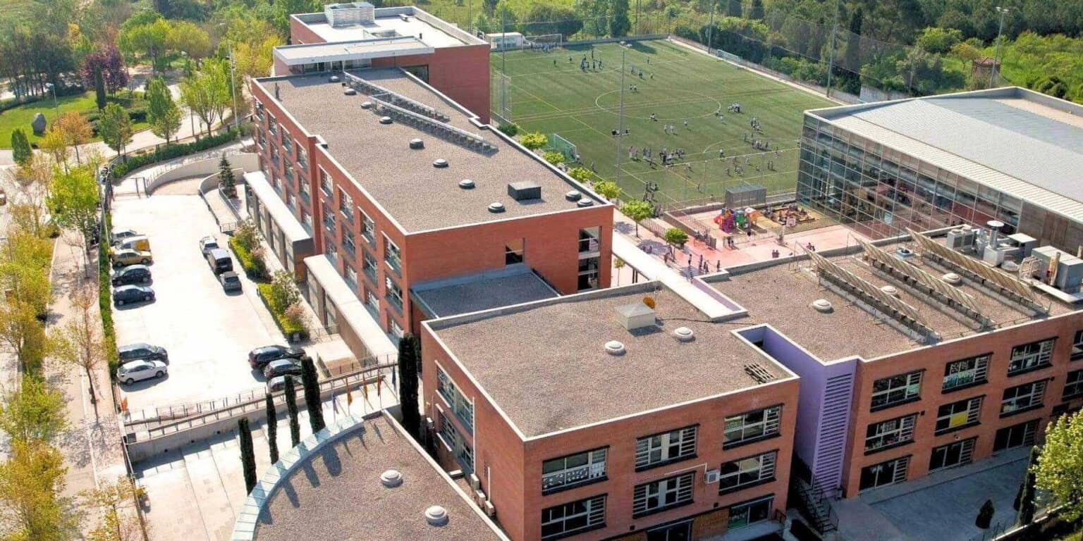 Modern school campus with sports fields and multiple buildings, offering top international education.