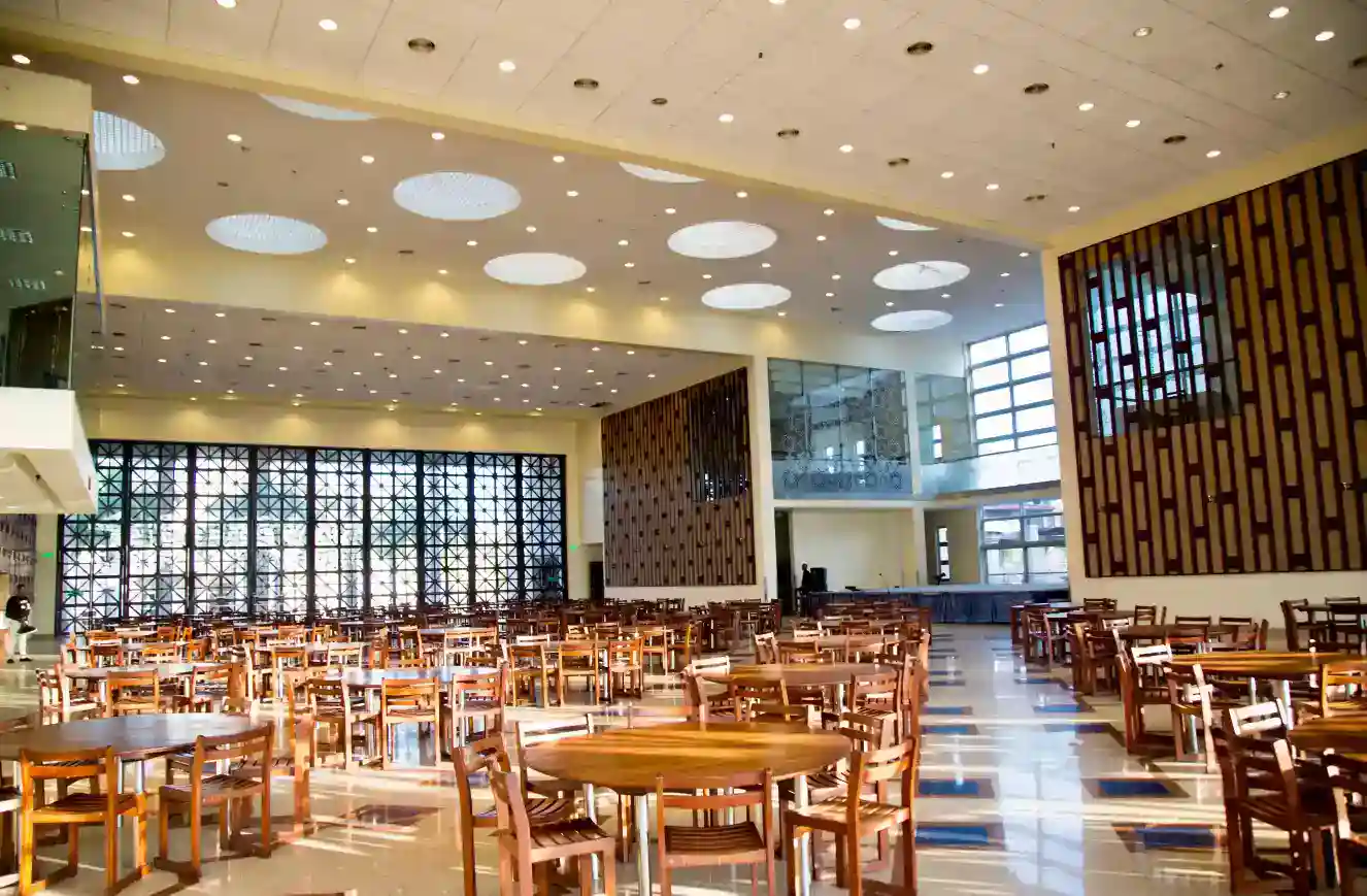 كافتيريا المدرسة الحديثة ذات المقاعد الفسيحة والإضاءة الطبيعية، وهي مثالية لتناول الطعام والتواصل الاجتماعي بين الطلاب.