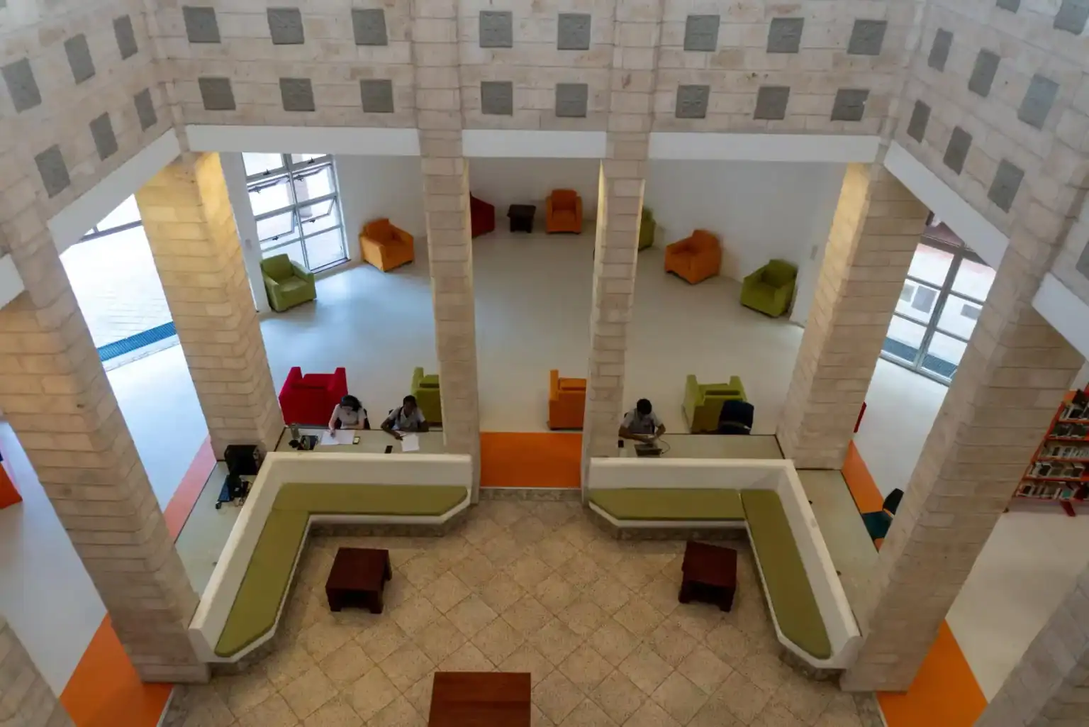 ردهة المدرسة العصرية المشرقة ذات المقاعد الملونة ومحطات عمل الطلاب، مما يعزز بيئة تعليمية نابضة بالحياة.