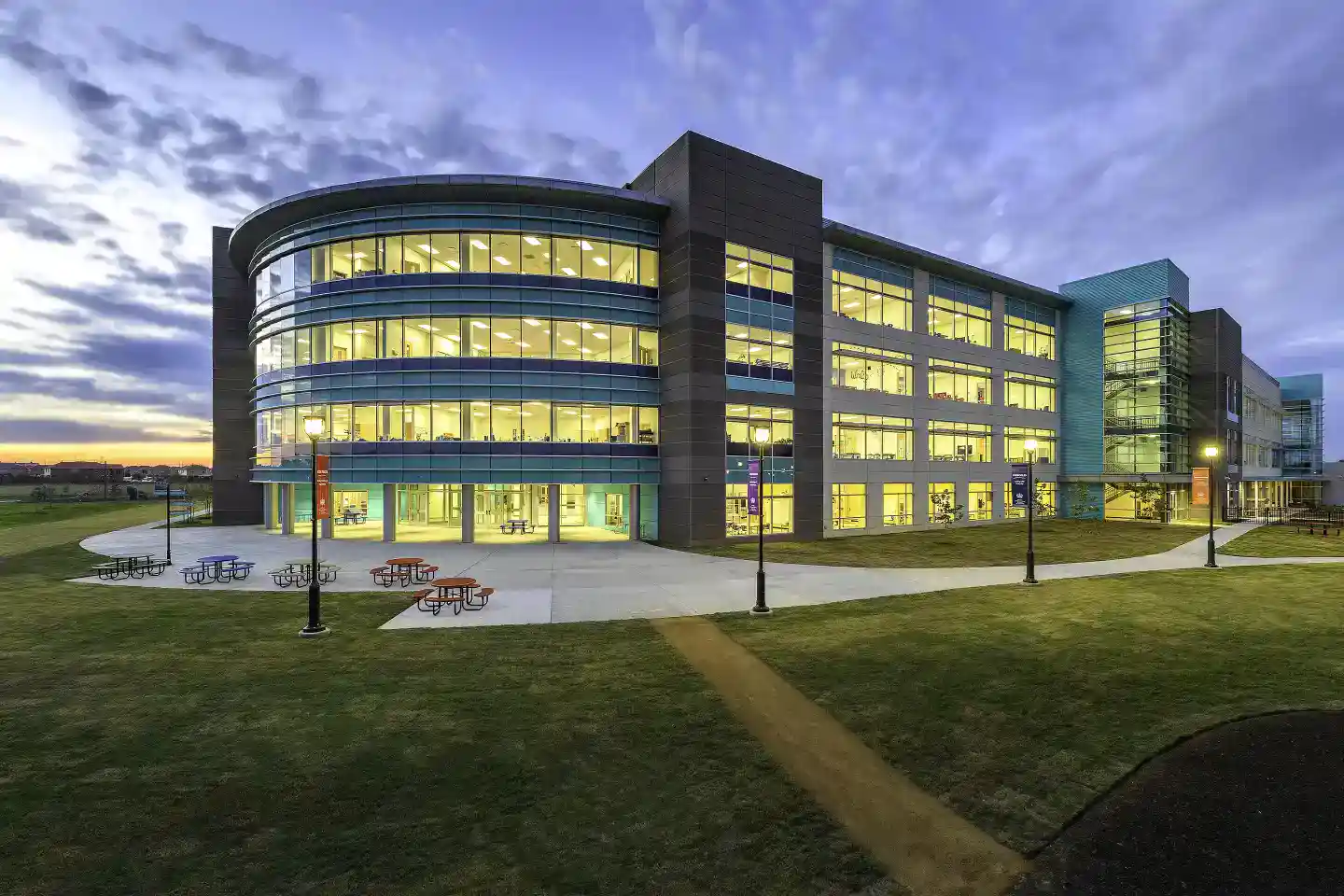 Modern classroom building at World Schools educational campus with illuminated interior.