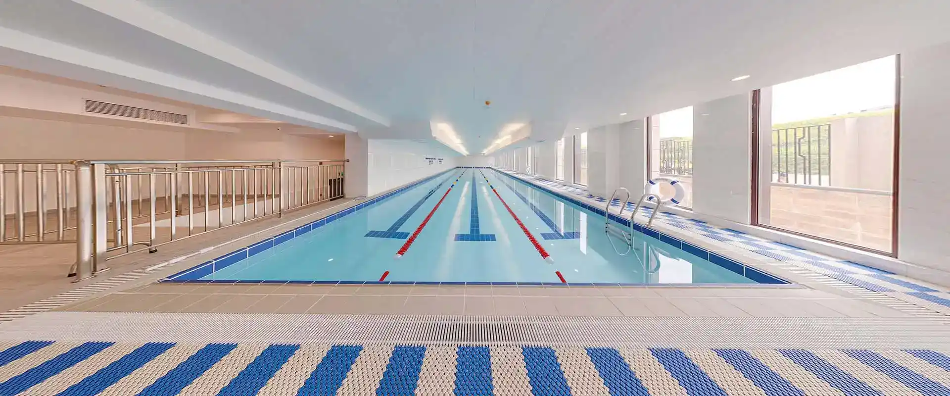 Modern indoor swimming pool at world schools with large windows and natural light, ideal for student recreation and aquatic training.