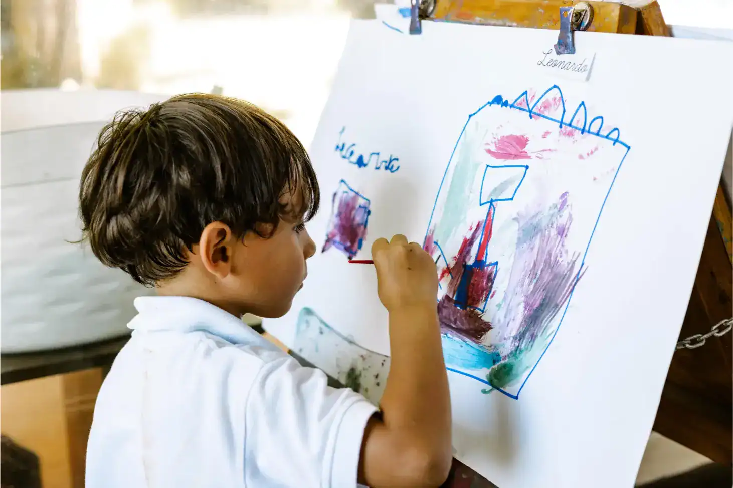 Creative young student painting colorful artwork at a world schools event, fostering creativity and global education.