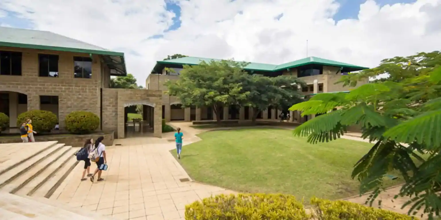 Modern school campus with green surroundings and students walking outside.
