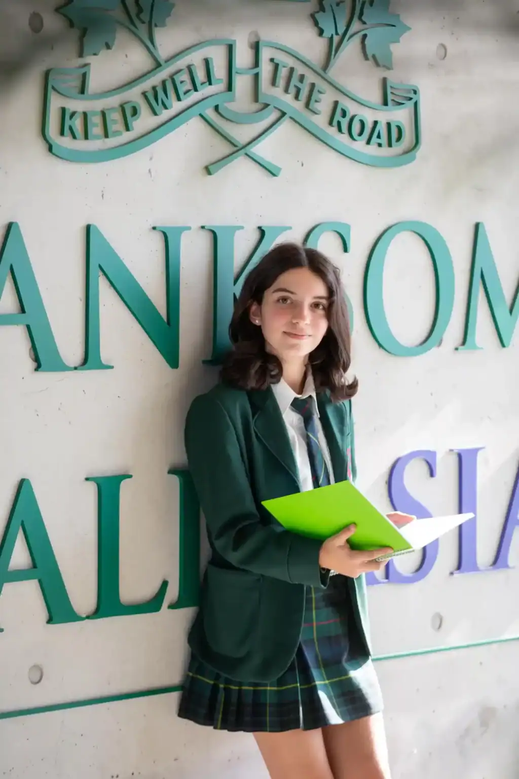 Bright young student in school uniform at an international school entrance, emphasizing global education and academic excellence.