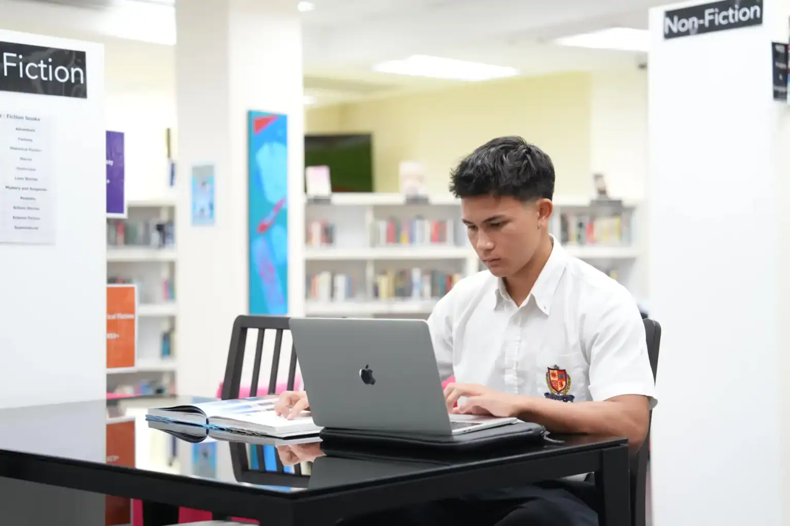 Estudiante estudiando en una biblioteca en un entorno educativo de escuelas del mundo, centrado en la excelencia académica.