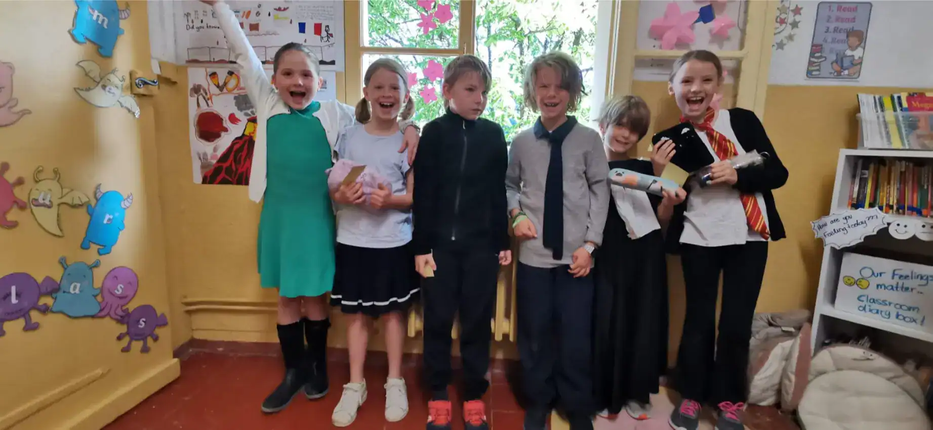 Bright children celebrating in a classroom, showcasing engaged learning at a World School.