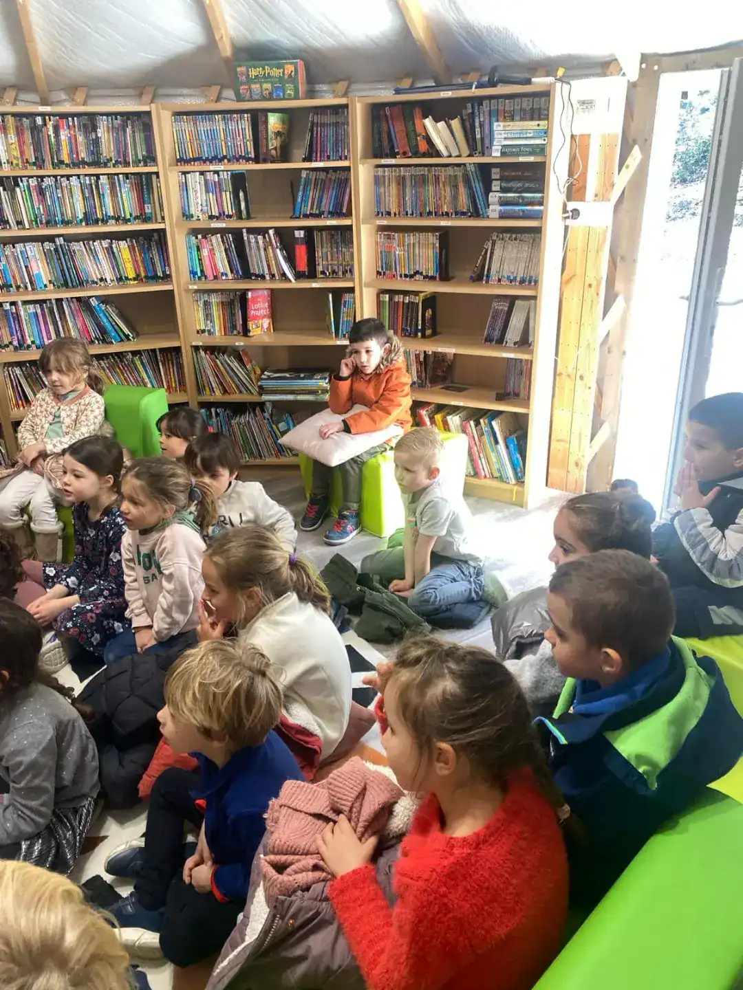 Bright classroom at a World Schools library with attentive children engaged in reading or storytelling activities.