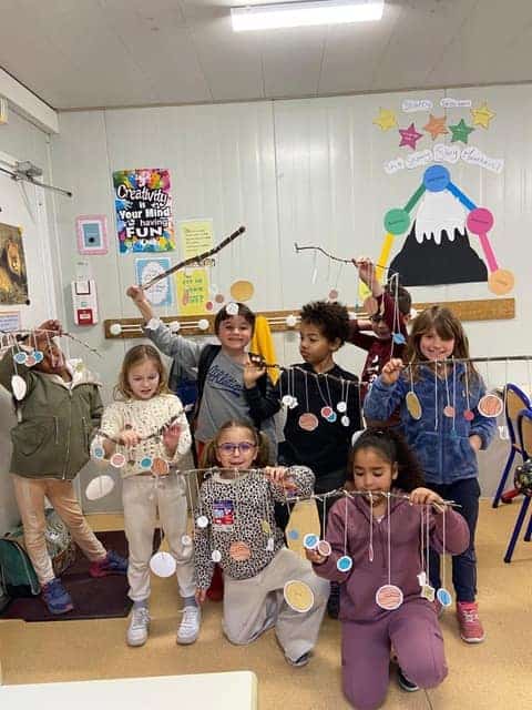 Colorful classroom children engaging in art activity at a World Schools educational setting.