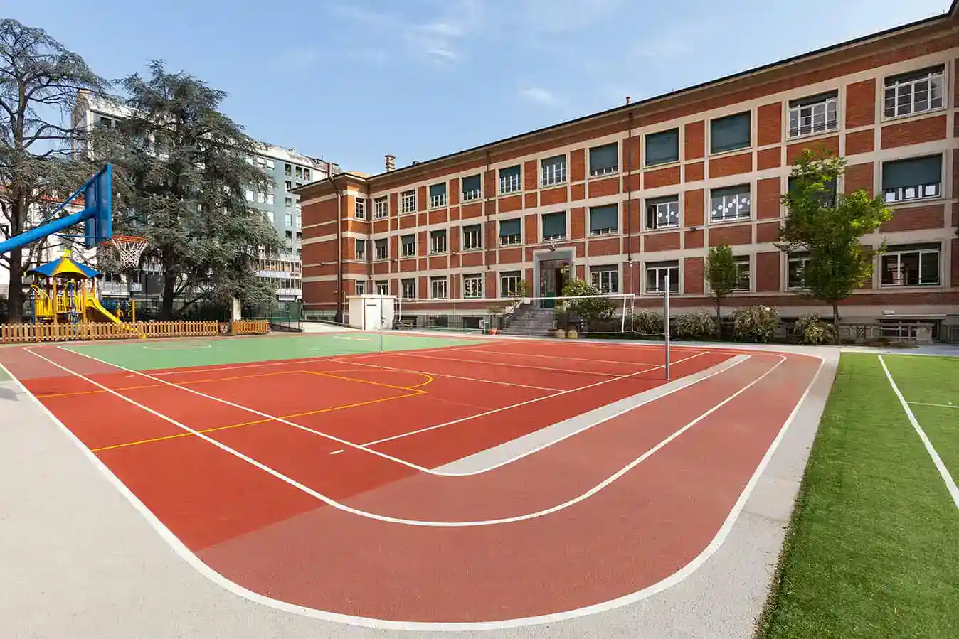 Bright school playground featuring a tennis court and playground area at World Schools.