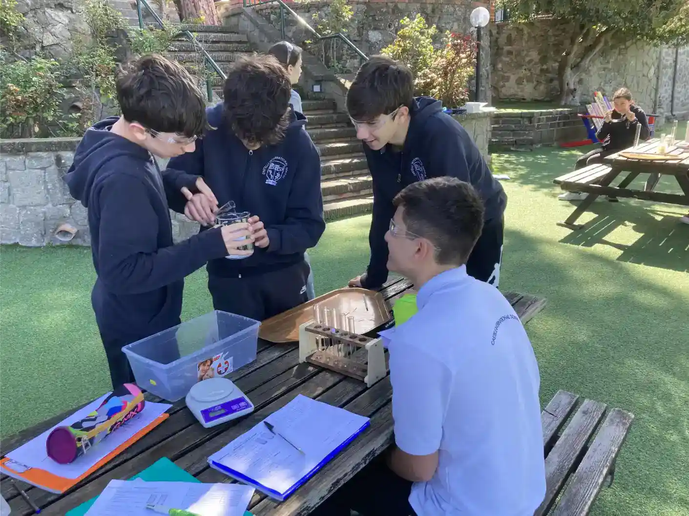 Students conducting science experiments outdoors at a World Schools educational program.