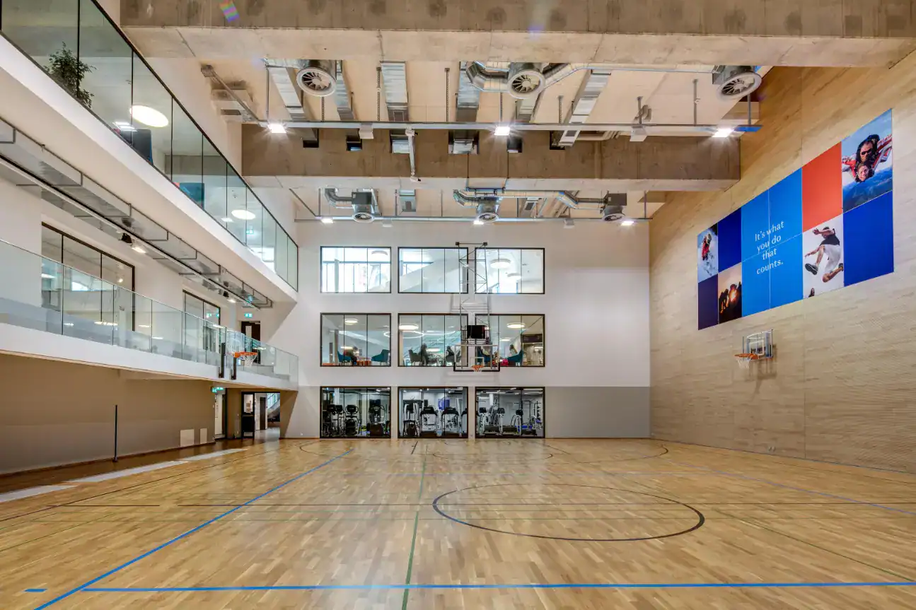 Modern indoor sports gymnasium with basketball courts and gym equipment, part of World Schools' state-of-the-art facilities.